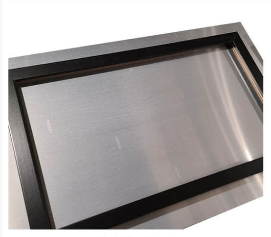 Le dos d’un tirage acrylique encadré produit en atelier, montrant le fil d’accrochage et les protections d’angle
